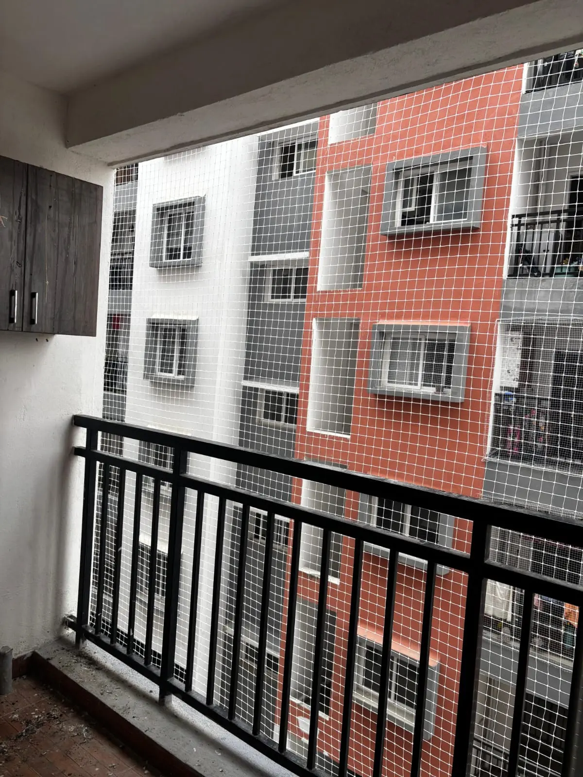 Tensioned copolymer balcony protection screen on apartment facade